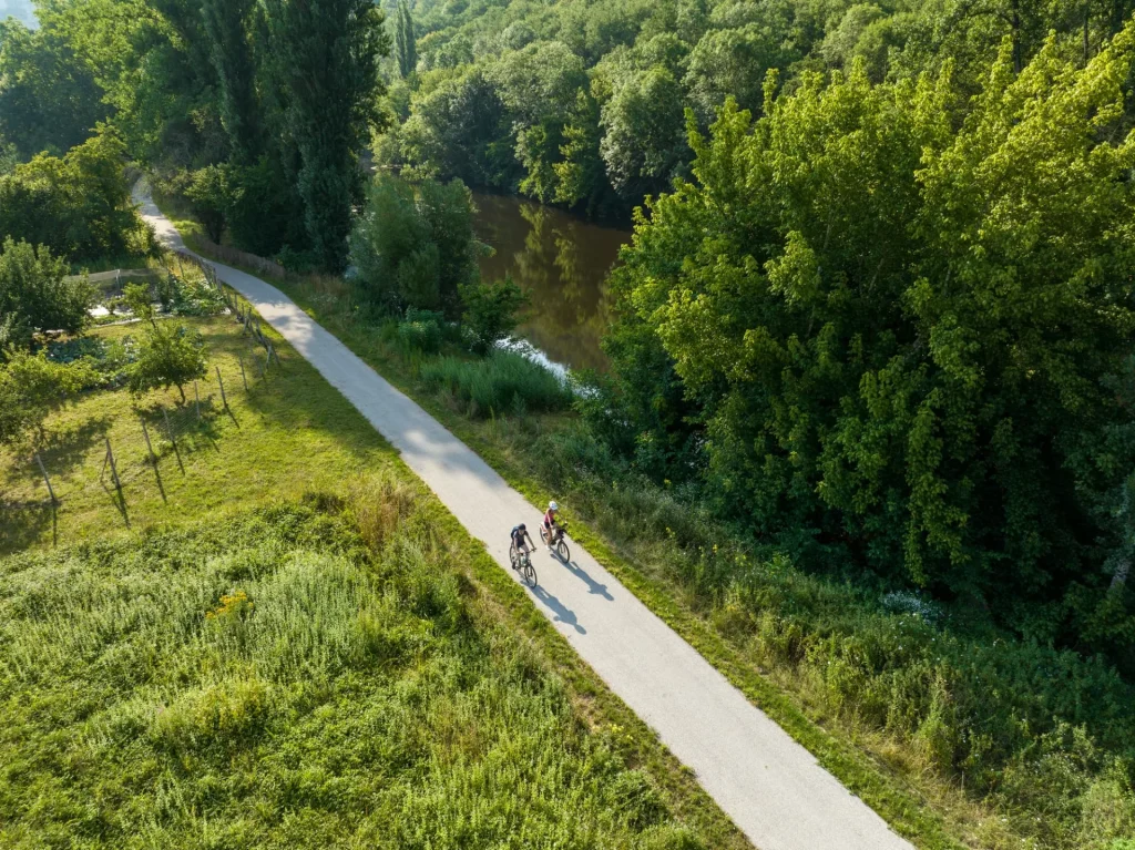 Caminante y ciclista de montaña en la vía verde del valle del Vézère, en Dordoña